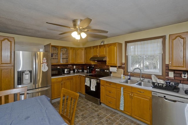 kitchen with appliances with stainless steel finishes, tasteful backsplash, sink, ceiling fan, and a textured ceiling