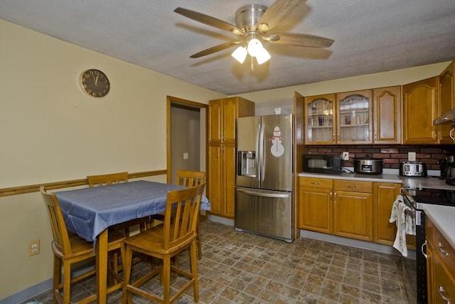 kitchen with backsplash, stainless steel appliances, and ceiling fan