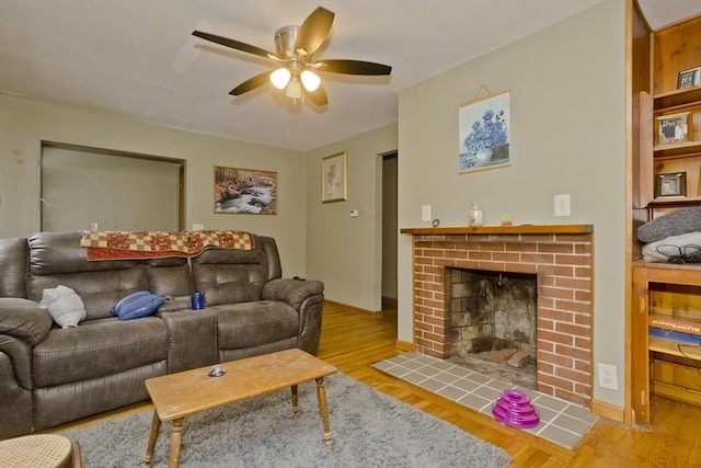 living room with ceiling fan, light wood-type flooring, and a fireplace