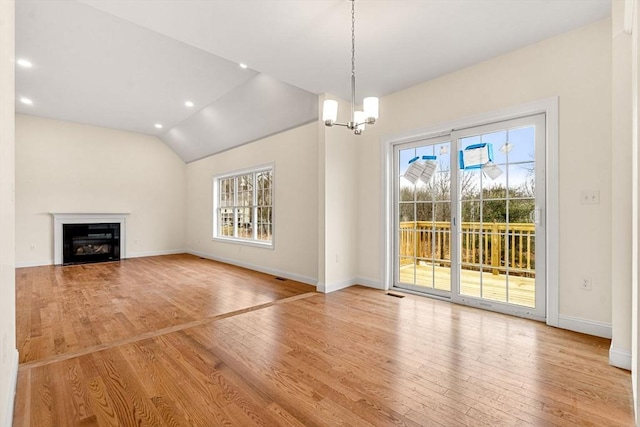 66-3 Parish Rd, Georgetown, MA 01833 - unfurnished living room featuring plenty of natural light, wood finished floors, a chandelier, baseboards, and vaulted ceiling