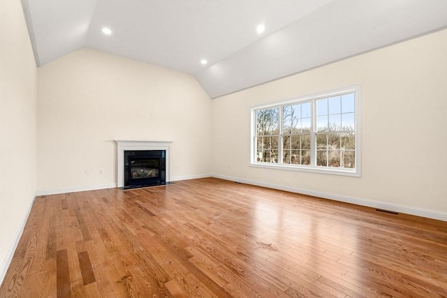 66-3 Parish Rd, Georgetown, MA 01833 - unfurnished living room with vaulted ceiling, light wood-style flooring, a fireplace with flush hearth, baseboards, and recessed lighting
