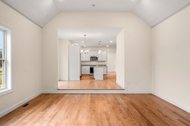 66-3 Parish Rd, Georgetown, MA 01833 - unfurnished living room with vaulted ceiling, light wood finished floors, baseboards, a chandelier, and recessed lighting