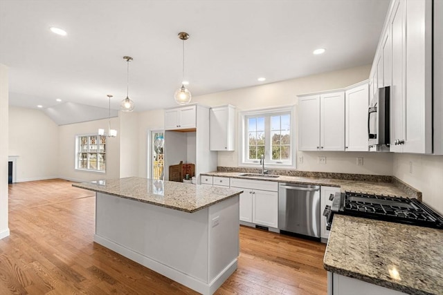 66-3 Parish Rd, Georgetown, MA 01833 - kitchen with stainless steel appliances, a sink, white cabinets, a kitchen island, and light wood-type flooring