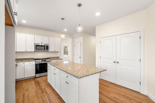 66-3 Parish Rd, Georgetown, MA 01833 - kitchen featuring appliances with stainless steel finishes, a kitchen island, light wood finished floors, white cabinets, and recessed lighting