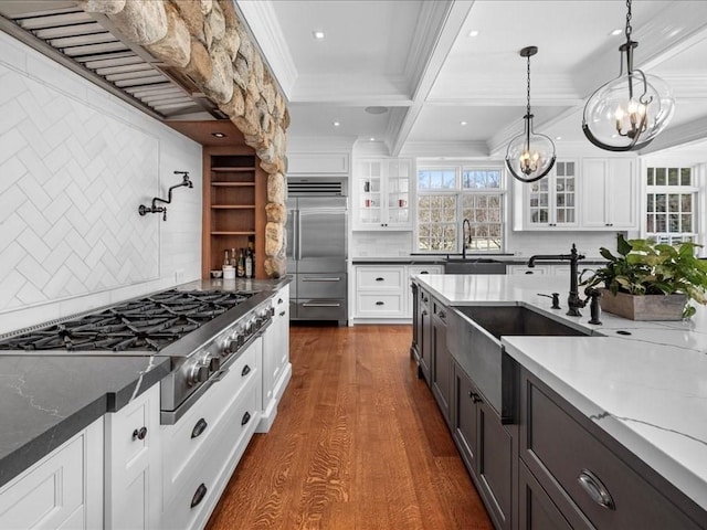 kitchen featuring crown molding, stainless steel appliances, glass insert cabinets, white cabinets, and a sink