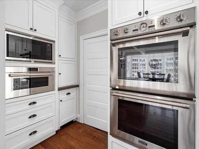 kitchen with stainless steel appliances, dark wood-style flooring, white cabinetry, and crown molding