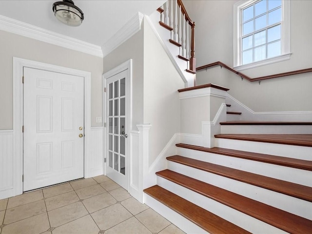 foyer featuring ornamental molding, stairs, and light tile patterned floors