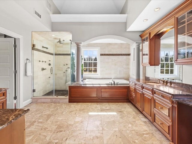 full bathroom featuring a garden tub, visible vents, vanity, a stall shower, and decorative columns