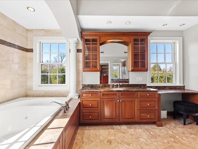 interior space featuring recessed lighting, a healthy amount of sunlight, decorative columns, and a sink