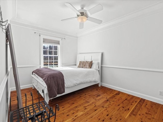 bedroom with ceiling fan, ornamental molding, wood finished floors, and baseboards