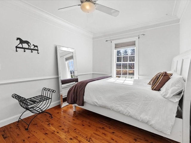 bedroom featuring baseboards, ornamental molding, ceiling fan, and wood finished floors