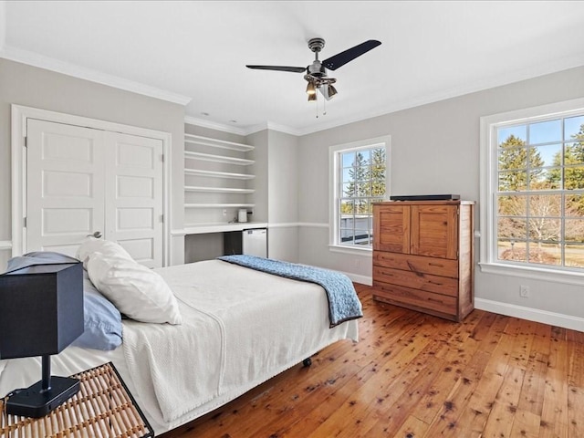 bedroom with ornamental molding, multiple windows, light wood finished floors, and baseboards