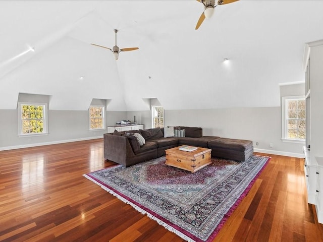 living area with high vaulted ceiling, ceiling fan, baseboards, and wood finished floors