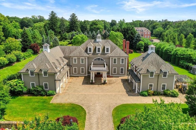 view of front of house featuring decorative driveway and a front lawn