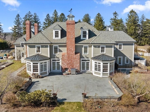 back of house with metal roof, a patio, french doors, and a standing seam roof