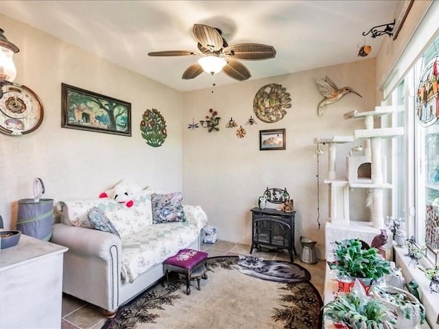 1244 Corktree E, Port Charlotte, FL 33952 - living area with plenty of natural light, a ceiling fan, a wood stove, and tile patterned floors