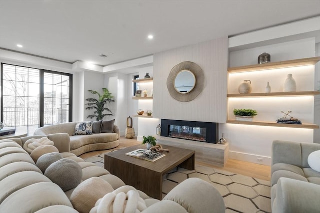 living room with light hardwood / wood-style flooring and built in features