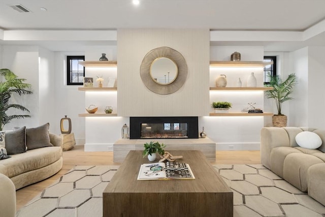 living room with a multi sided fireplace and light hardwood / wood-style floors