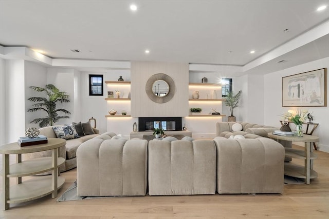 living room featuring light hardwood / wood-style floors and a large fireplace