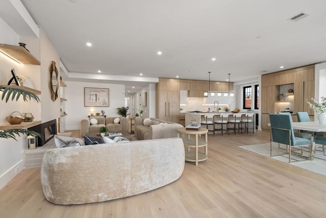 living room with sink and light wood-type flooring