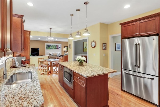 15 Sylvan Dr, Stow, MA 01775 - kitchen with appliances with stainless steel finishes, a sink, light wood finished floors, decorative light fixtures, and light stone countertops