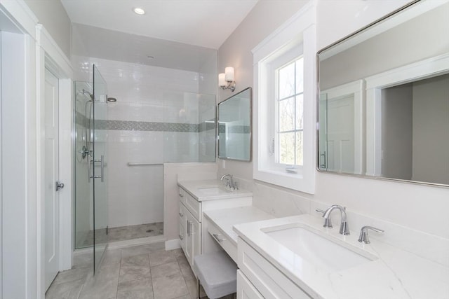 bathroom with a shower stall, two vanities, and recessed lighting