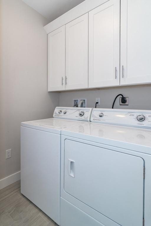 laundry room featuring independent washer and dryer, cabinet space, and baseboards