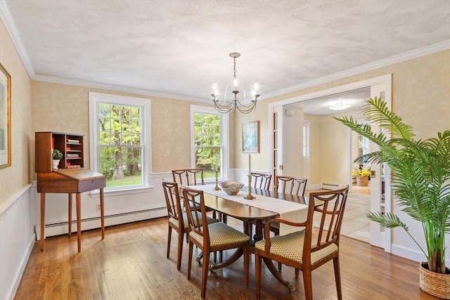 163 Candlestick Rd, North Andover, MA 01845 - dining space featuring a baseboard heating unit, wood-type flooring, a chandelier, wainscoting, and crown molding