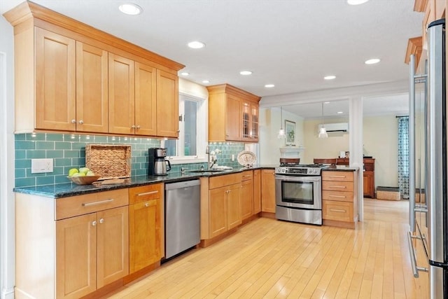 163 Candlestick Rd, North Andover, MA 01845 - kitchen featuring stainless steel appliances, a sink, a peninsula, light wood finished floors, and backsplash