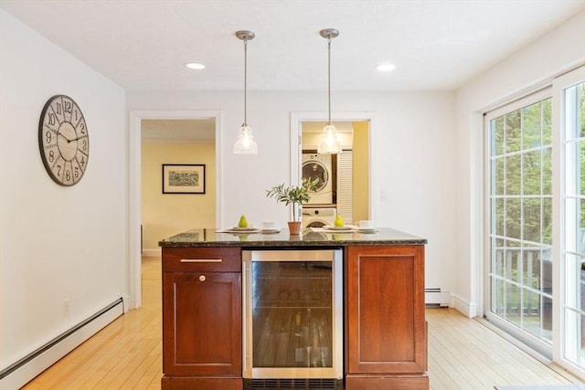 163 Candlestick Rd, North Andover, MA 01845 - bar area with beverage cooler, baseboard heating, stacked washer / drying machine, light wood-type flooring, and pendant lighting