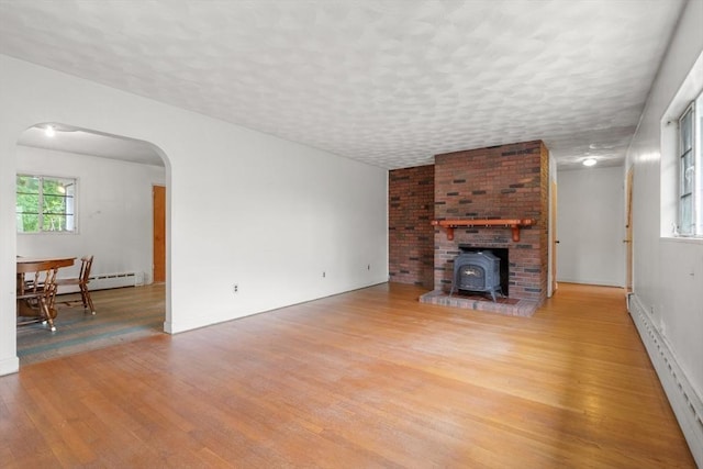 14 Forty Steps Ln, Nahant, MA 01908 - living area featuring wood finished floors, a wood stove, arched walkways, and baseboard heating