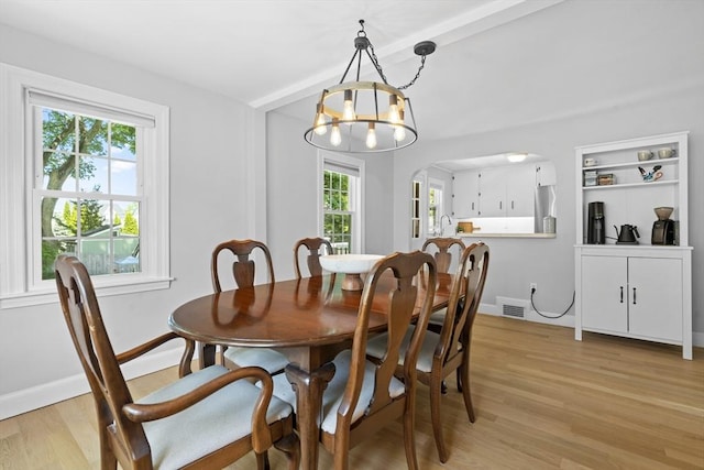 230 Beal Rd, Waltham, MA 02453 - dining room featuring light wood-style floors, a chandelier, baseboards, arched walkways, and beam ceiling