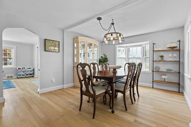 230 Beal Rd, Waltham, MA 02453 - dining room with arched walkways, light wood-type flooring, a chandelier, and baseboards