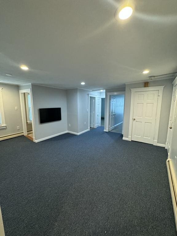 unfurnished living room with a baseboard radiator and dark colored carpet