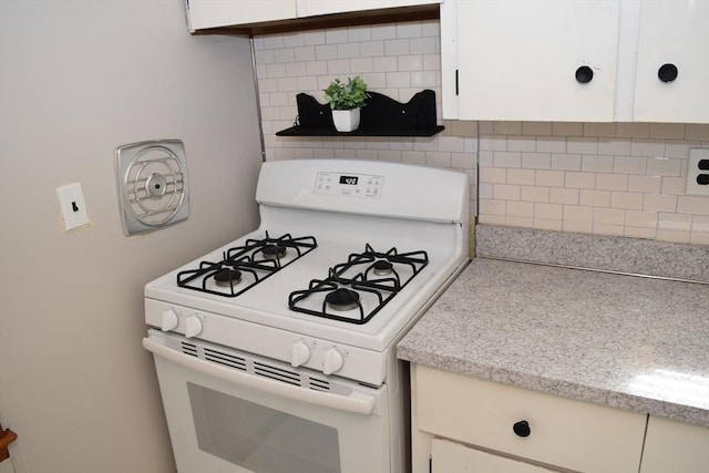 130 Windham Rd, Boston, MA 02136 - kitchen featuring white gas stove, light countertops, backsplash, and white cabinets