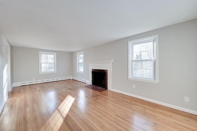 unfurnished living room featuring light hardwood / wood-style flooring, a brick fireplace, and a baseboard radiator