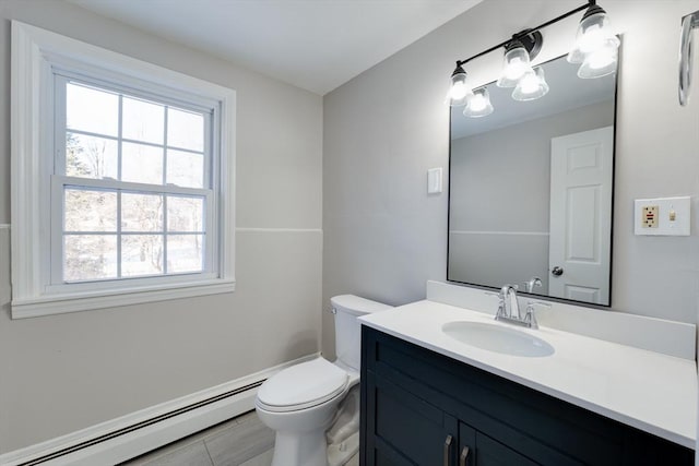 bathroom featuring vanity, a baseboard heating unit, and toilet