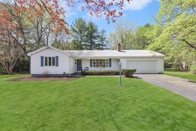single story home featuring an attached garage, a front yard, driveway, and a chimney