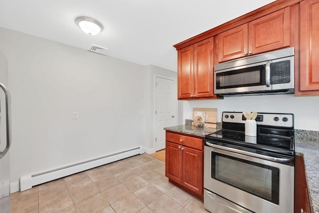kitchen with brown cabinets, light tile patterned flooring, visible vents, stainless steel appliances, and a baseboard heating unit