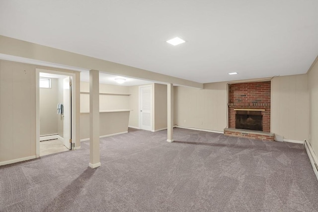 finished below grade area with carpet floors, baseboard heating, baseboards, and a brick fireplace