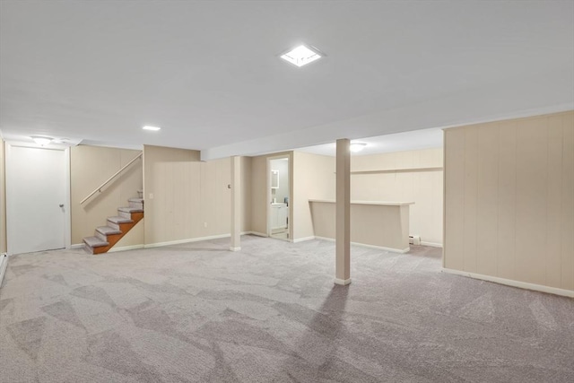 finished below grade area with carpet flooring, baseboards, and stairway