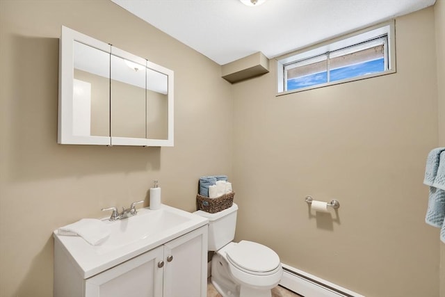 bathroom featuring vanity, a baseboard heating unit, and toilet