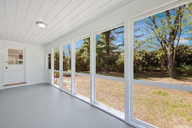 unfurnished sunroom with wooden ceiling and concrete floors