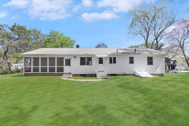 rear view of property featuring a lawn, a sunroom, a chimney, and entry steps