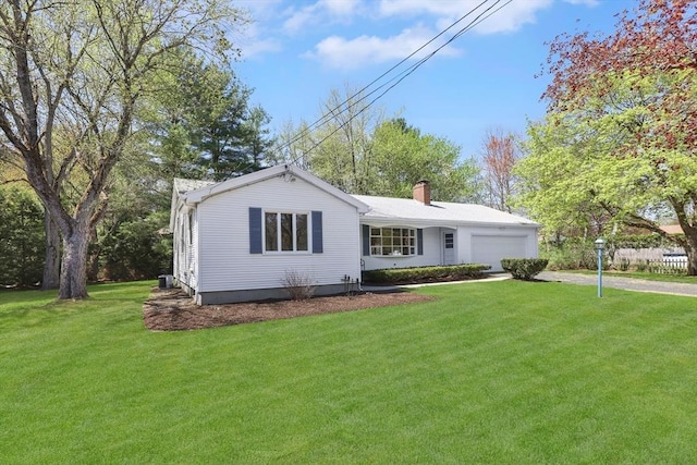 ranch-style house featuring an attached garage, a front yard, driveway, and a chimney