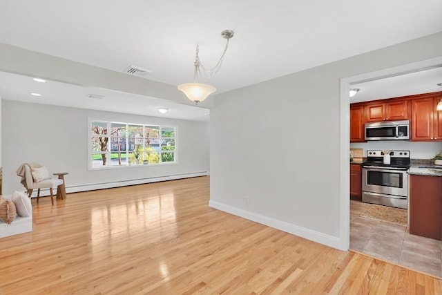 interior space featuring baseboards, a baseboard heating unit, visible vents, and light wood-type flooring