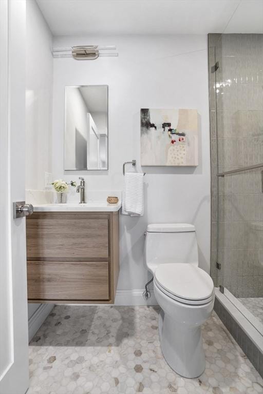 bathroom featuring toilet, tile patterned flooring, a shower with shower door, and vanity