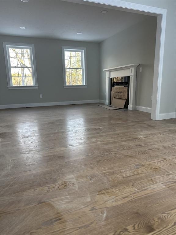 unfurnished living room featuring hardwood / wood-style floors and a wealth of natural light