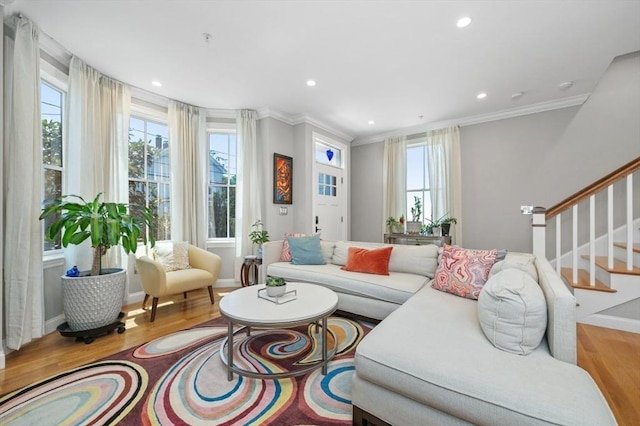 living room featuring wood finished floors, plenty of natural light, stairs, crown molding, and recessed lighting