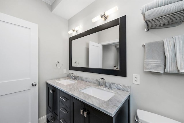 bathroom featuring toilet and double vanity